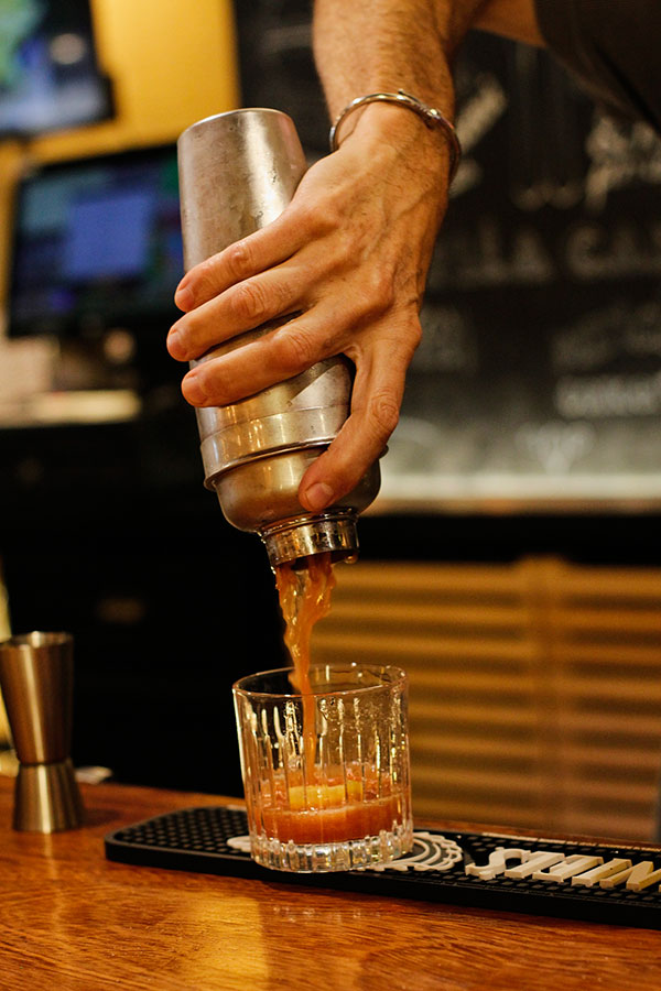Coctelera sirviendo vermut en vaso
